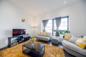 a living room with a couch and a tv at 2 Bed Oasis London Flat-O2-Excel-Canary Wharf- Shops- Trains -Free Parking,Wifi 500mb & Flex Check In in Woolwich