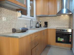 uma cozinha com armários de madeira e uma bancada em Myrina View 3 em Mesochórion