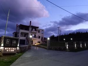 Uma casa branca com um cartaz à frente. em Myrina View 3 em Mesochórion