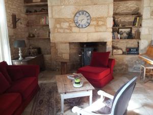a living room with a clock on a stone wall at Napoléon in Montignac