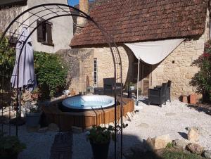 an outdoor hot tub in a yard next to a building at Napoléon in Montignac +23 photos