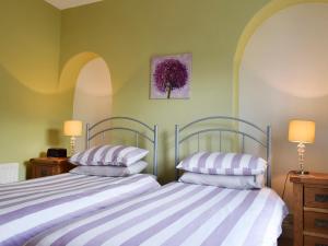 deux lits côte à côte dans une chambre dans l'établissement Poachers Cottage, à Keswick