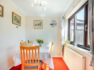 a dining room with a table and a window at Langford Cottage in Ringstead