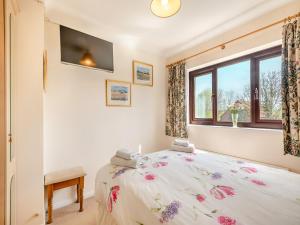 a bedroom with a bed and a window at Langford Cottage in Ringstead +10 photos