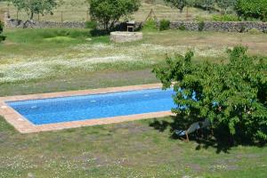 a swimming pool in the middle of a field at Agua Antigua Casa Rural in Gargüera