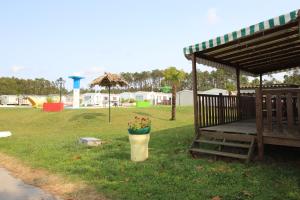 a park with a gazebo with flowers in a bucket at Land's Hause Bungalows par La Conciergerie Française Emplacement 11AA in Pataias