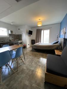 Un dormitorio con una cama y una mesa y sillas. en Ojo de Agua Mono, en San Martín de los Andes