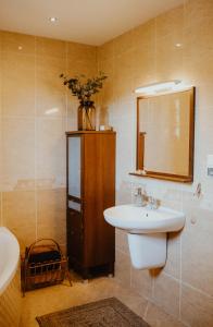 ein Badezimmer mit Waschbecken und Spiegel in der Unterkunft Sielanka Dom nad Morzem in Sławoszyno