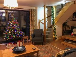 a living room with a christmas tree in a room at The Coach House - Ukc2772 in Sandwich +25 photos