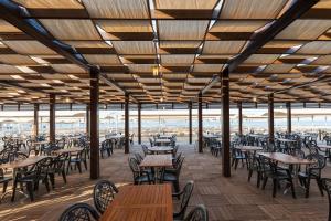 a restaurant with wooden tables and chairs and tables and tablesktop at Primasol Hane Garden Hotel in Side