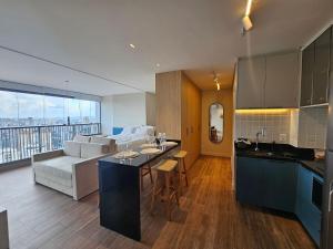 a kitchen and living room with a couch and a table at Studio Tatuapé - SP in São Paulo