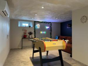 a room with a ping pong table in a living room at L'évasion Cinégame - Gîte à thème in Diebolsheim