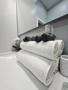 une pile de serviettes posée sur une salle de bain dans l'établissement 5BR Home near City Center, Live! Casino, Hot Tub with City View, à Philadelphie