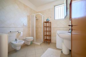 a bathroom with a toilet and a sink and a shower at Villetta Lu Sule in Alezio +12 photos
