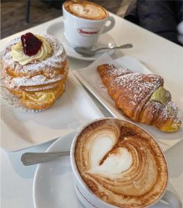 a table with two plates of pastries and a cup of coffee at La Castellese in Aci Castello