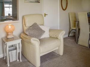 a chair with a pillow on it in a living room at Mr Seal - Uk41452 in Hunstanton