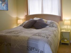 a bedroom with a bed with two pillows and a window at Mr Seal - Uk41452 in Hunstanton +9 photos