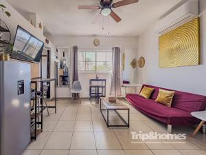 a living room with a purple couch and a kitchen at Sea View Terrace 1BR Apartment 1 Block to Malecón in La Paz