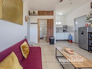 a living room with a purple couch and a table at Sea View Terrace 1BR Apartment 1 Block to Malecón in La Paz