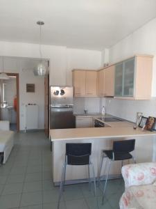 a kitchen with a counter and two chairs in it at Elisavet in Afitos