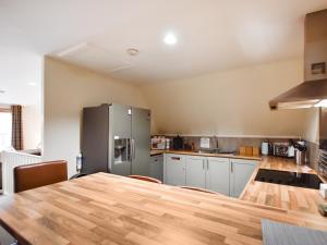 a kitchen with a table and a refrigerator at Ptarmigan Lodge in Balmaha