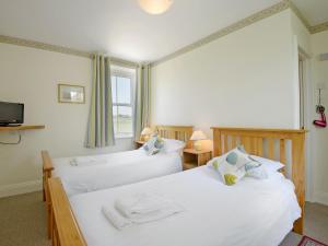 two twin beds in a room with a window at Fernlea in Langton Matravers