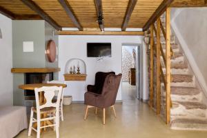 a living room with a staircase and a table and chairs at Pappoudiko Myrto's Residence in Ágios Geórgios Sykoúsis