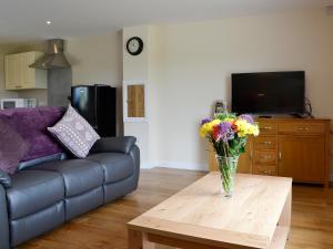 a living room with a vase of flowers on a coffee table at Dolview in Penybont