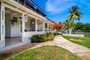 a white house with a palm tree in the background at Dorado Del Mar Villa by PH in Dorado