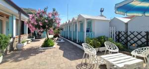 a patio with two white chairs and a bench at Terrazza sul Mare in Lido di Camaiore