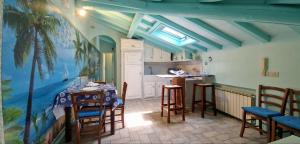 a room with a table and chairs and a kitchen at Terrazza sul Mare in Lido di Camaiore