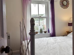 a bedroom with a bed and a window at The Cottage in St Ives