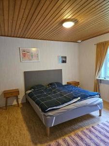 a bed in a bedroom with a wooden ceiling at Lillstugan Albohult in Hok