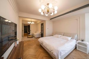 a bedroom with a large white bed and a chandelier at ZHome-FuDi Garden-Near the Bund in Shanghai