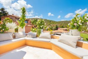 a patio with a white couch and pillows at Luxury Pevero Apartment in Golf Club in Abbiadori