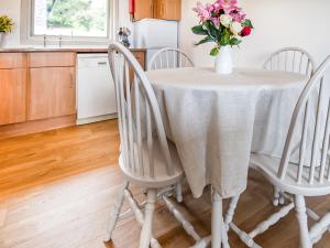 a kitchen table with a vase of flowers on it at Rowan Lodge in Resolis