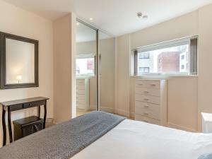 スウォンジーにあるApartment 13のベッドと机と窓のある寝室