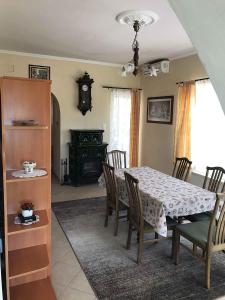 a dining room with a table and chairs and a clock at Holiday home in Balatonalmadi 38980 in Balatonalmádi