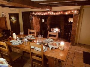 a dining room table with candles and a fireplace at Old Church Farm in Hinstock
