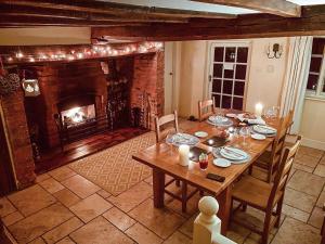 a dining room with a table and a fireplace at Old Church Farm in Hinstock