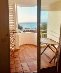 a room with a balcony with a view of the ocean at Résidence TARTANE - Apt ZANDOLI - Vue Mer in La Trinité