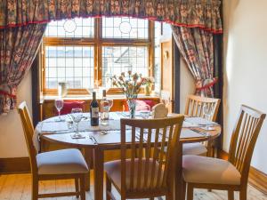 a dining room with a table with chairs and a window at The Old Workshop in Great Yarmouth