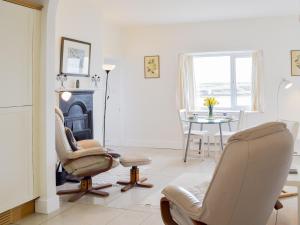 a living room with chairs and a table and a fireplace at Cliff Cottage - Uk43207 in Dale