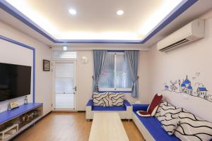 ein Wohnzimmer mit einem blauen Sofa und einem TV in der Unterkunft Simple Travel in Donggang