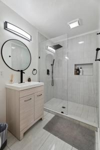 a bathroom with a shower with a sink and a mirror at Uptown Okc Studio Paseo Arts & Bricktown #22a in Oklahoma City