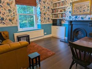 a living room with a couch and a fireplace at Aelybryn in Llangwyryfon