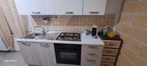 a small kitchen with a stove and a sink at An&Gy house in Tursi