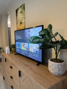 a flat screen tv sitting on top of a wooden dresser at Oberon's Rest - Spacious 2 Bed Home perfect for Contractors & Families near Shipley, Bradford in Bradford