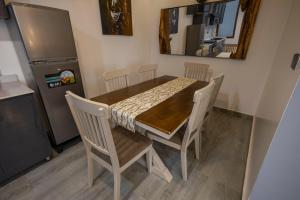 a dining room table with chairs and a refrigerator at Airgo Residences in Kigali
