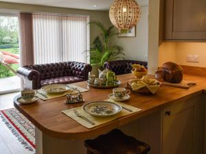 a kitchen with a wooden table with food on it at Swallowtail Lodge in Brundall